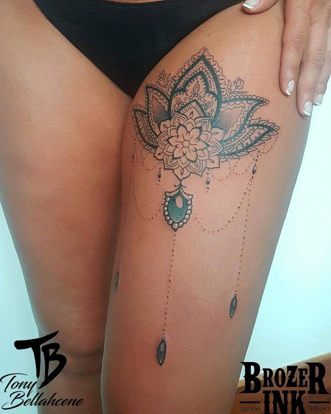Tatouage ornemental lotus et pendeloques sur la cuisse
