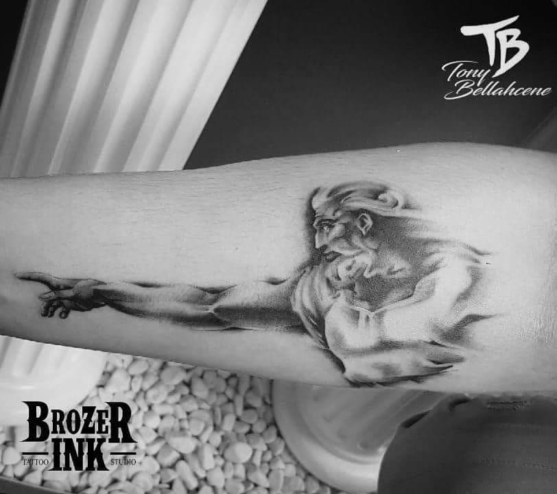 Tatouage réaliste noir et gris : La Création d'Adam sur l'avant-bras
