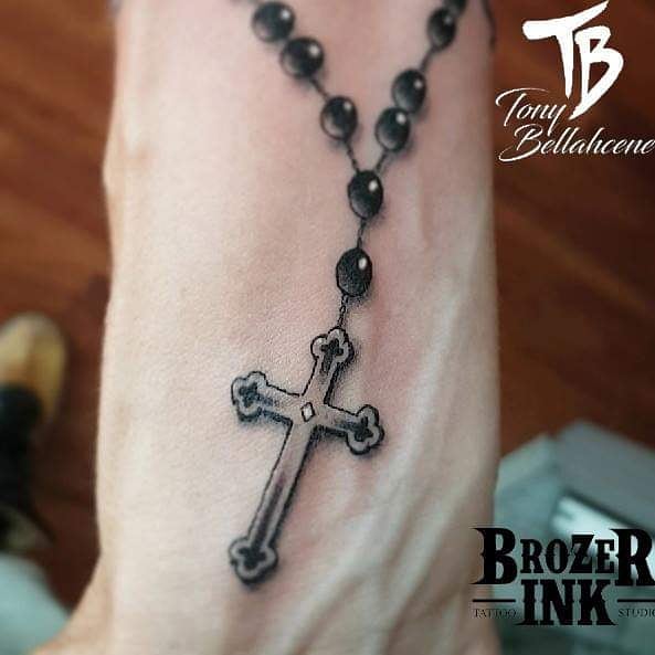 Tatouage chapelet et croix en noir et gris sur le pied