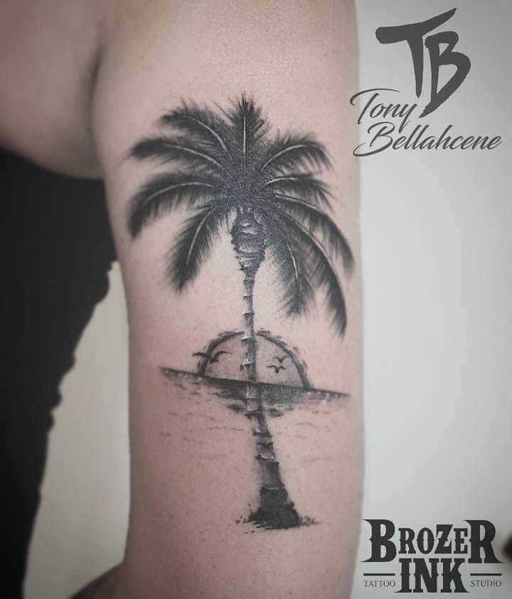 Tatouage palmier et coucher de soleil sur le bras
