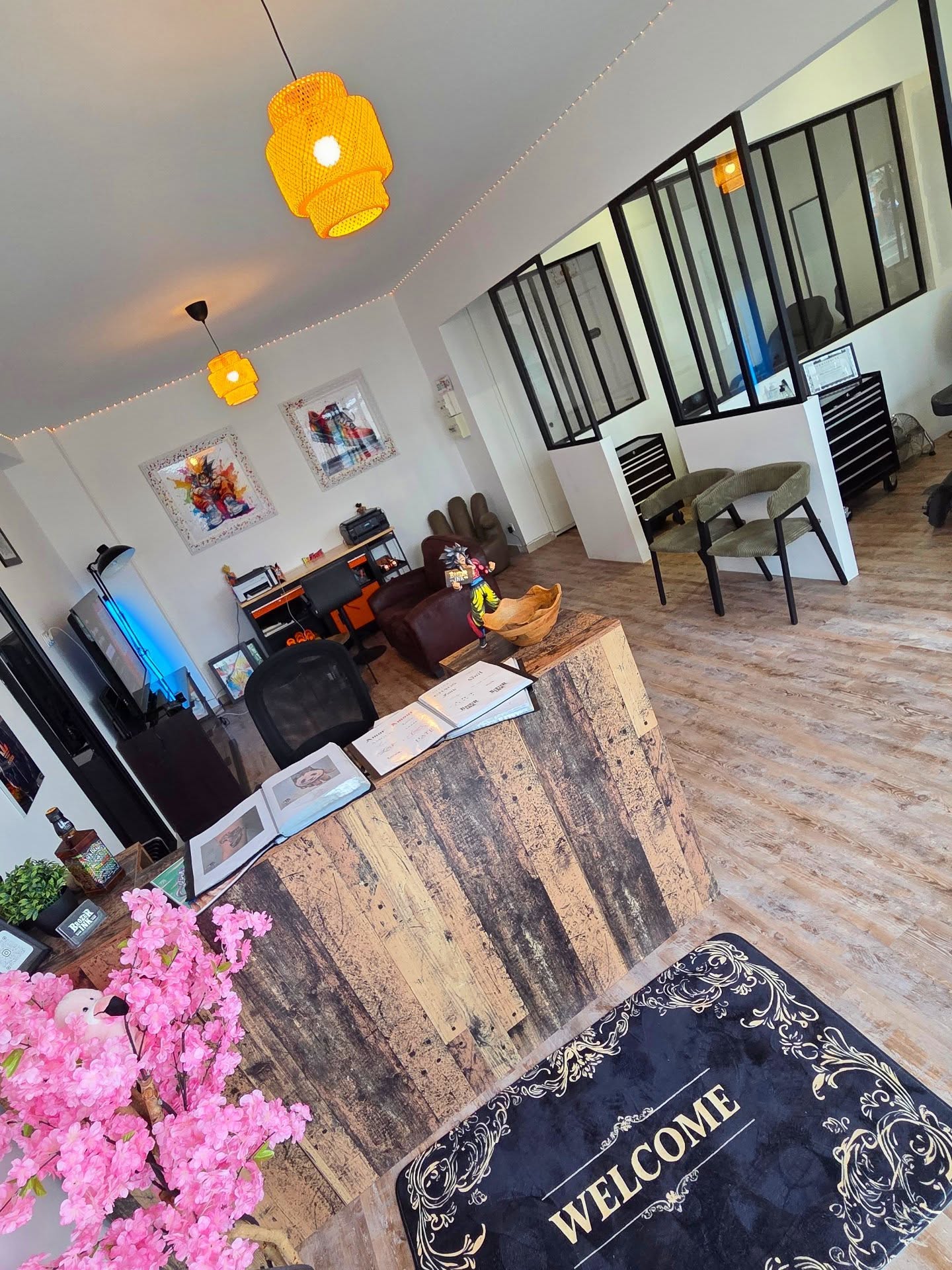 Accueil du studio : comptoir en bois brut et books de tatouage